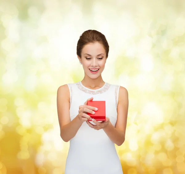 Mujer sonriente sosteniendo caja de regalo roja — Foto de Stock