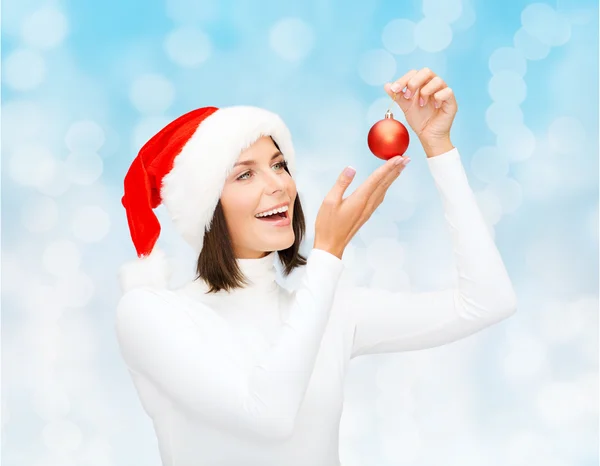 Mujer en sombrero de ayudante de santa con bola de Navidad — Foto de Stock