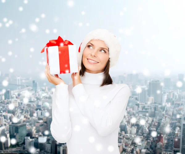 Donna sorridente in cappello Babbo Natale helper con confezione regalo — Foto Stock