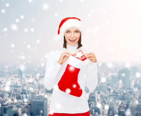 Mujer en sombrero de santa con caja de regalo y media — Foto de Stock