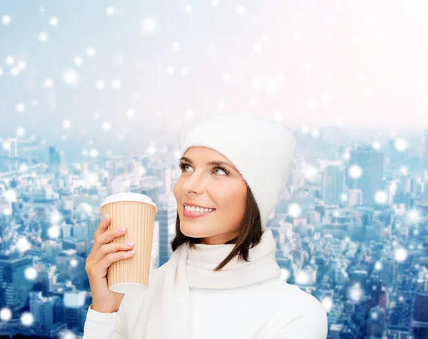 Улыбающаяся молодая женщина в зимней одежде с чашкой — стоковое фото