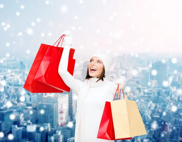 Sonriente joven con bolsas de compras rojas —  Fotos de Stock