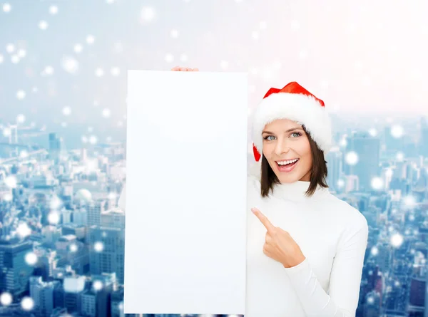 Sorridente giovane donna in cappello di Babbo Natale con tavola bianca — Foto Stock