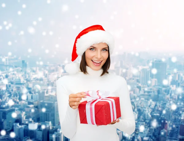 Donna sorridente in cappello Babbo Natale helper con confezione regalo — Foto Stock