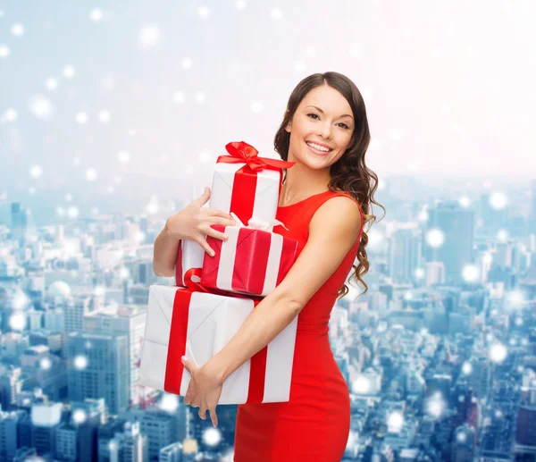 Mujer sonriente en vestido rojo con cajas de regalo —  Fotos de Stock