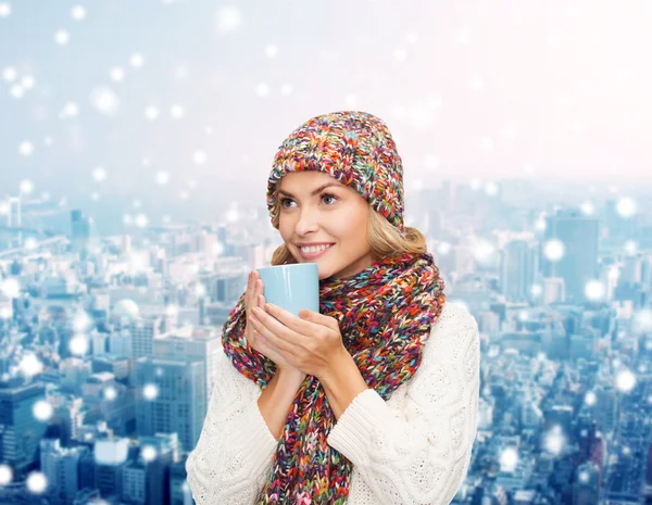 Leende ung kvinna i vinterkläder med kopp — Stockfoto