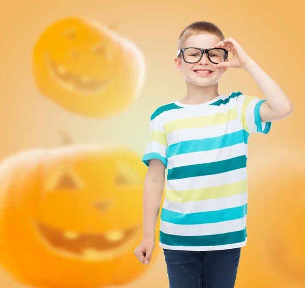 Lachende jongen in glazen over pompoenen achtergrond — Stockfoto