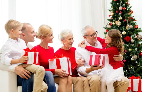 Famiglia sorridente con regali a casa — Foto Stock