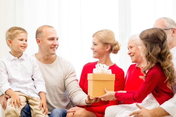 Lachende familie met cadeau thuis — Stockfoto