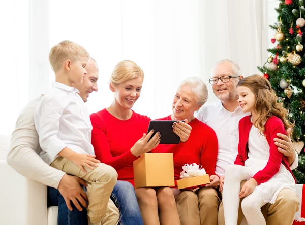 Familia sonriente con tablet pc y caja de regalo en casa — Foto de Stock