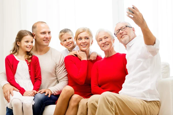 Família sorrindo com câmera em casa — Fotografia de Stock