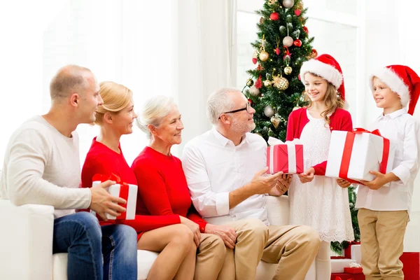 Smiling family with gifts at home — Stock Photo, Image