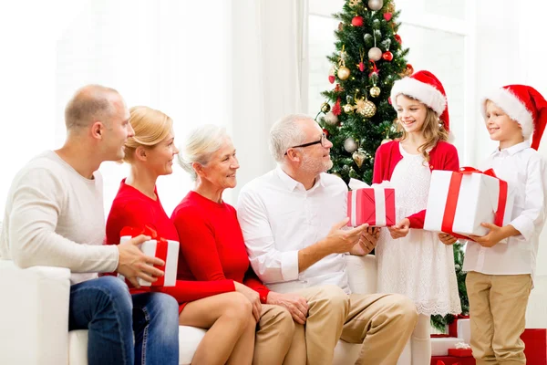 Famiglia sorridente con regali a casa — Foto Stock