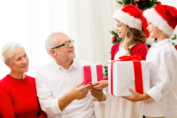 Família sorridente com presentes em casa — Fotografia de Stock