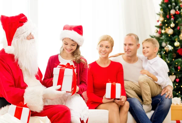 Famiglia sorridente con Babbo Natale e regali a casa — Foto Stock
