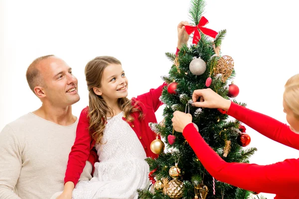 Smiling family decorating christmas tree at home — Stock Photo, Image