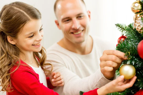 Smiling family decorating christmas tree at home — Stock Photo, Image