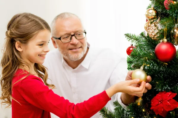 Lächelnde Familie schmückt Weihnachtsbaum zu Hause — Stockfoto