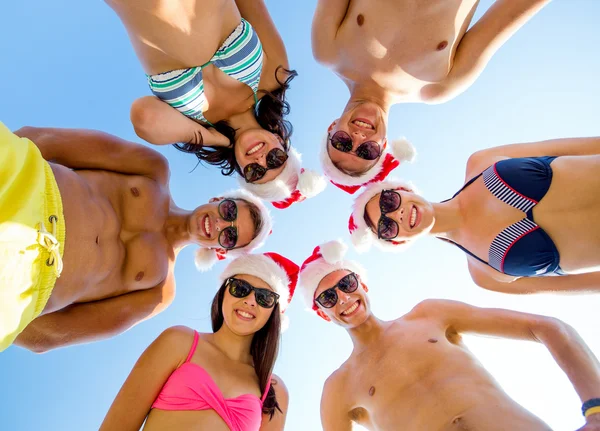 Smiling friends in circle on summer beach — Stock Photo, Image