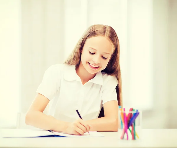 Kleine Schülerin zeichnet in der Schule — Stockfoto