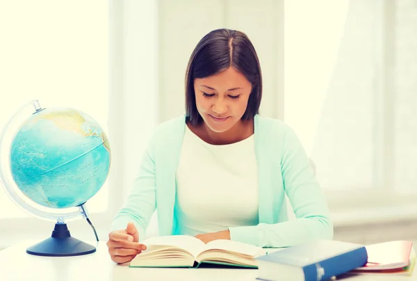 Lehrerin mit Globus und Buch in der Schule — Stockfoto