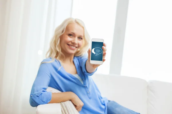 Lachende vrouw met smartphone thuis — Stockfoto