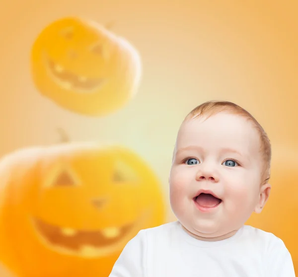 Glimlachende baby over pompoenen achtergrond — Stockfoto
