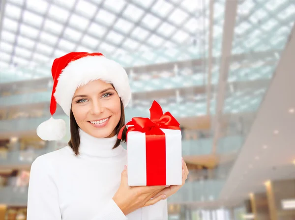 Donna sorridente in cappello Babbo Natale helper con confezione regalo — Foto Stock