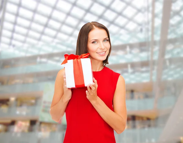 Lachende vrouw in rode jurk met doos van de gift — Stockfoto