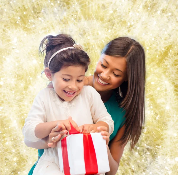 Счастливая мать и маленькая девочка с подарочной коробкой — стоковое фото