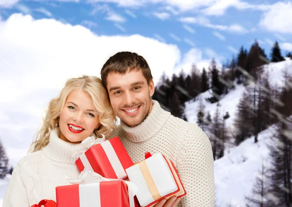 Glimlachende man en vrouw met presenteert — Stockfoto