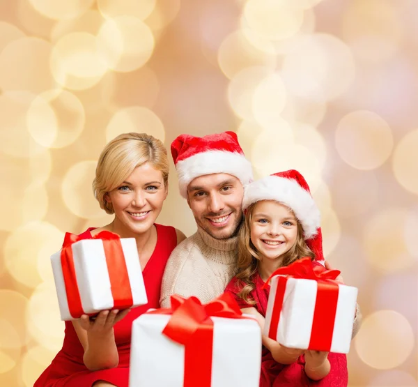 Familia feliz en sombreros de santa helper con cajas de regalo —  Fotos de Stock