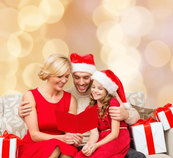 Famiglia felice in cappelli Babbo Natale aiutante con scatole regalo — Foto Stock