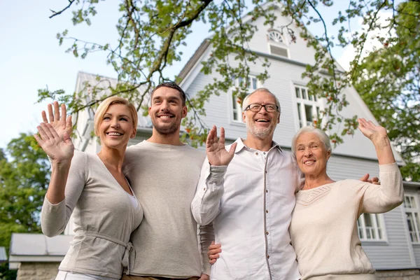 Familia feliz en frente de la casa al aire libre — Foto de Stock