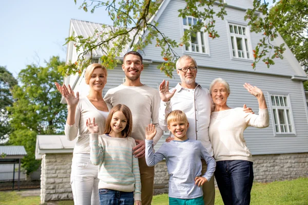 Familia feliz en frente de la casa al aire libre —  Fotos de Stock