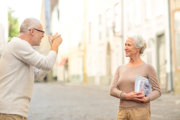 Пожилая пара фотографирует на городской улице — стоковое фото