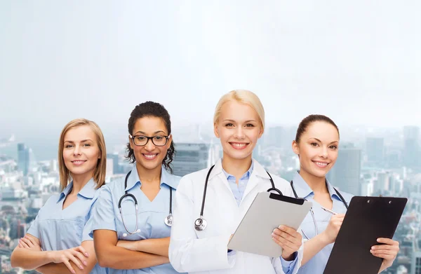 Smiling female doctor and nurses with tablet pc — Stock Photo, Image