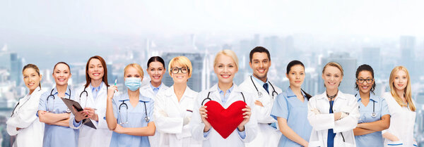 Smiling doctors and nurses with red heart Royalty Free Stock Photos