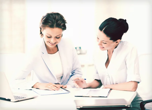 Two smiling businesswomen working in office — Stock Photo, Image