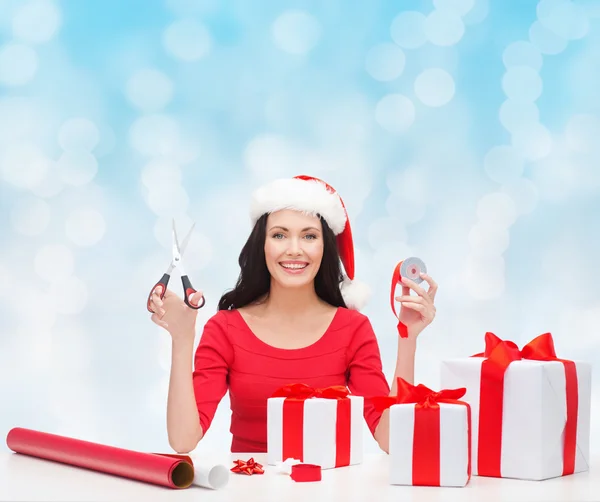 Santa yardımcı şapka hediye ambalaj içinde gülümseyen kadın — Stok fotoğraf