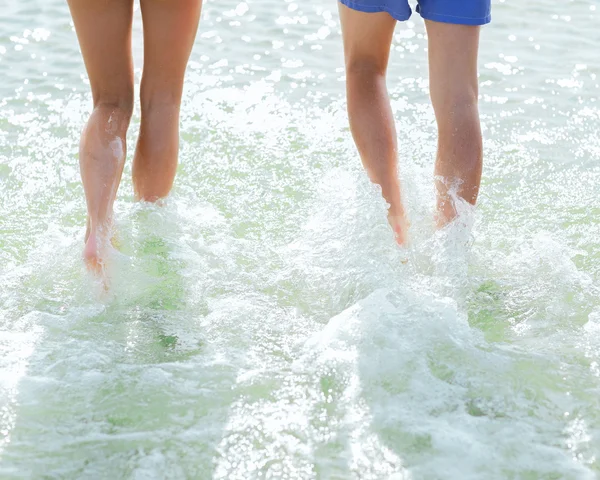 Close up de pernas humanas na praia de verão — Fotografia de Stock