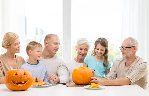 Familia feliz sentado con calabazas en casa —  Fotos de Stock