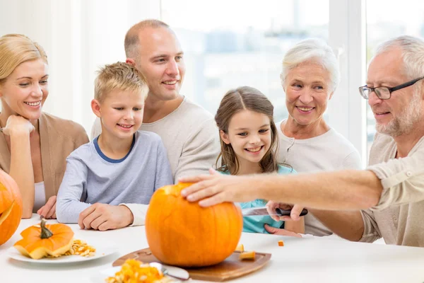 Glückliche Familie sitzt mit Kürbissen zu Hause — Stockfoto