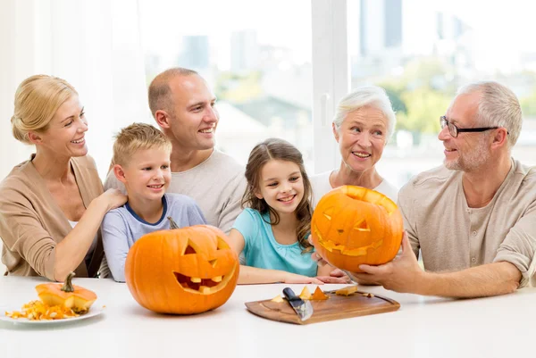 Happy family sitting with pumpkins at home — Stock Photo, Image