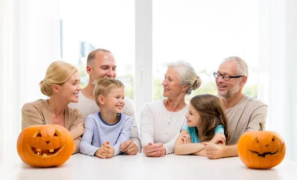 Família feliz sentado com abóboras em casa — Fotografia de Stock