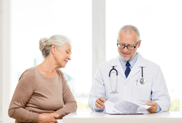 Sonriente mujer mayor y reunión de médico — Foto de Stock