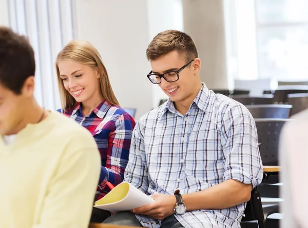 Gruppe lächelnder Studenten mit Notizbuch — Stockfoto