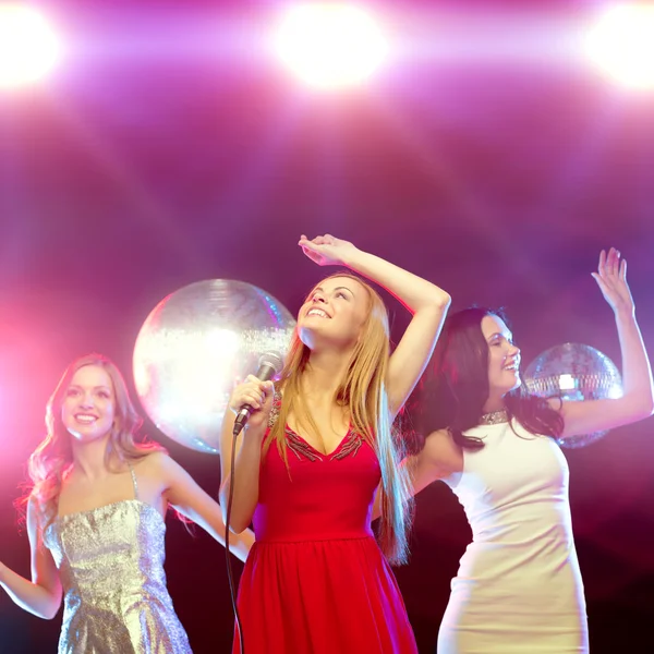 Tres mujeres sonrientes bailando y cantando karaoke —  Fotos de Stock