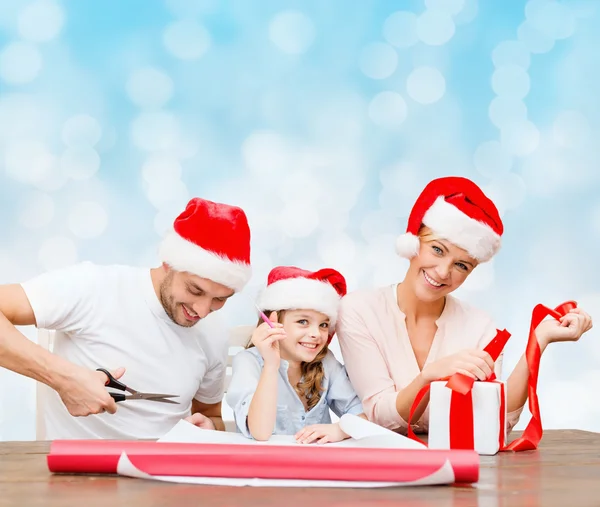 Família feliz em santa helper chapéus presente embalagem — Fotografia de Stock