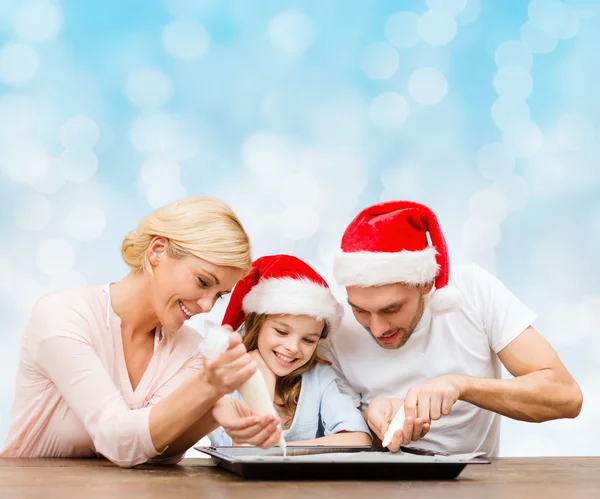 Feliz familia en santa helper sombreros de cocina — Foto de Stock